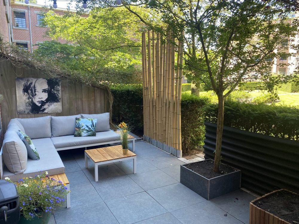 De binnentuin met loungeset, bamboe en een boom